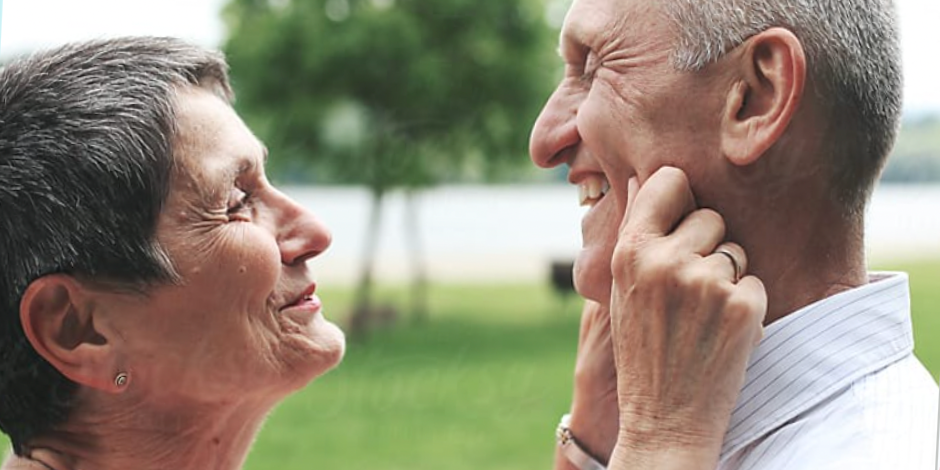 Elder couple with woman pinching man's cheeks